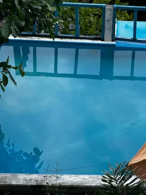 a swimming pool with blue water and a fence at Hotel Silver Lake in Santa Ana
