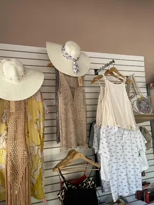 two hats and dresses are hanging on a wall at Sambo Mambo Beach Hotel in El Cuco