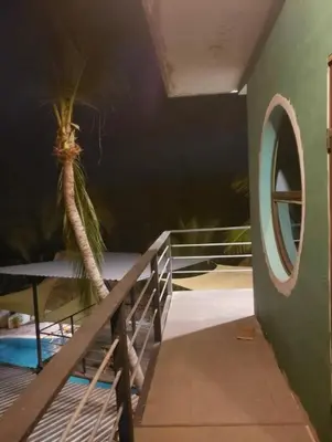 a room with a staircase and a palm tree at Lote 44 Guesthouse in El Zonte