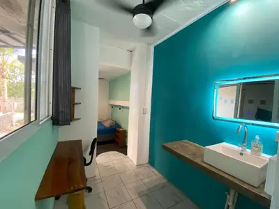 a bathroom with a sink and a blue wall at Lote 44 Guesthouse in El Zonte