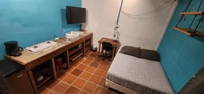 a small room with a sink and a bed at Lote 44 Guesthouse in El Zonte