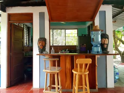 a kitchen with a bar and two stools at Lote 44 Guesthouse in El Zonte