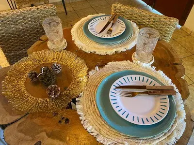 a wooden table with plates and utensils on it at Orquídea Loft in Juayúa