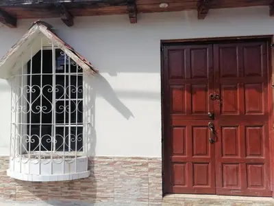 a red door and a cage on the side of a building at Orquídea Loft in Juayúa