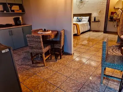 a room with a table and chairs and a bed at Orquídea Loft in Juayúa