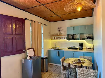 a kitchen with blue cabinets and a table in a room at Orquídea Loft in Juayúa