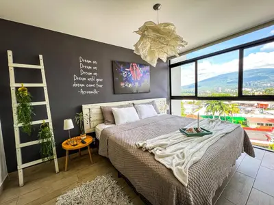a bedroom with a bed and a chalkboard wall at Avitat Joy 2Brm Amazing City&Volcano View Pool&Gym in San Salvador