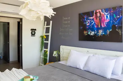 a bedroom with a bed with a tv on the wall at Avitat Joy 2Brm Amazing City&Volcano View Pool&Gym in San Salvador