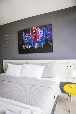 a bedroom with a white bed with a tv on the wall at Avitat Joy 2Brm Amazing City&Volcano View Pool&Gym in San Salvador