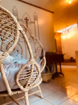 a wicker rocking chair in a room with a piano at Cafeto Loft Lovely and private loft in Ruta de las Flores heart in Juayúa