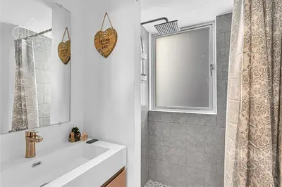 a bathroom with a white sink and a shower at Cozy, Modern and Centric Apartment with pool and gym in San Salvador