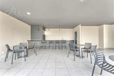 a restaurant with tables and chairs in a room at Cozy, Modern and Centric Apartment with pool and gym in San Salvador