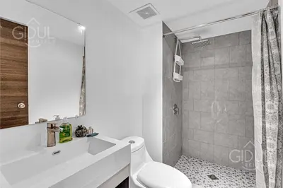 a white bathroom with a toilet and a shower at Cozy, Modern and Centric Apartment with pool and gym in San Salvador