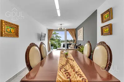 a dining room with a long table and chairs at Cozy, Modern and Centric Apartment with pool and gym in San Salvador
