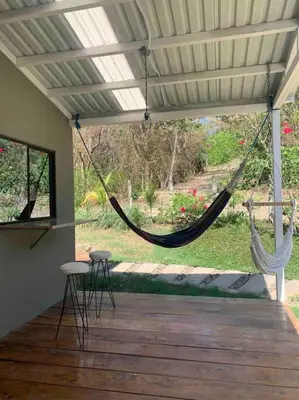 a porch with a hammock hanging from a roof at Wabi Sabi , casa de playa in Tamanique