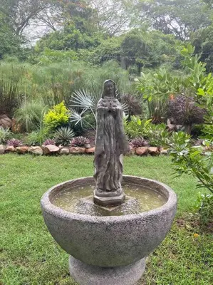 a statue of a woman sitting on top of a fountain at Wabi Sabi , casa de playa in Tamanique