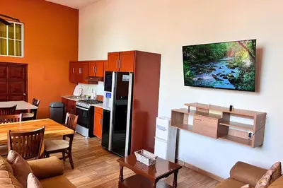 a kitchen with a refrigerator and a table in it at Quinta Sunrise, Lago de Coatepeque in El Congo