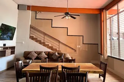 a dining room with a table and a couch at Quinta Sunrise, Lago de Coatepeque in El Congo