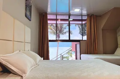 a bedroom with a large window with a view of the ocean at Quinta Sunrise, Lago de Coatepeque in El Congo