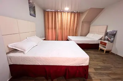 a hotel room with two beds and a window at Quinta Sunrise, Lago de Coatepeque in El Congo