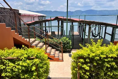 a building with stairs and a view of the water at Quinta Sunrise, Lago de Coatepeque in El Congo