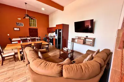 a living room with a couch and a dining room at Quinta Sunrise, Lago de Coatepeque in El Congo