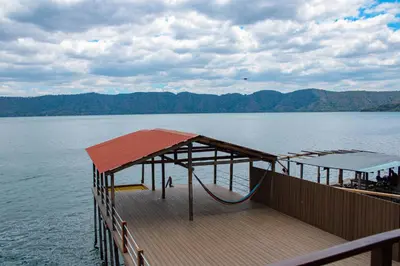a wooden deck with a playground on the water at Rancho Chanel, Lago de Coatepeque in El Congo