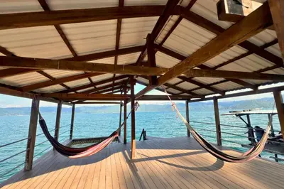 a hammock on a boat on the water at Rancho Chanel, Lago de Coatepeque in El Congo
