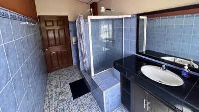 a blue tiled bathroom with a sink and a shower at Rancho Chanel, Lago de Coatepeque in El Congo