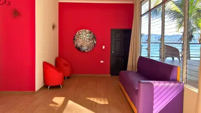 a living room with red walls and a purple couch at Quinta Sunset, Lago de Coatepeque in El Congo