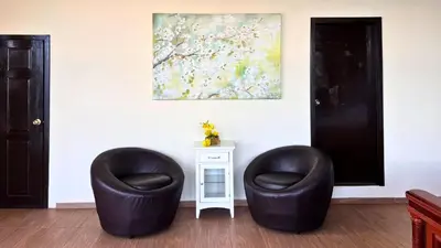 two black chairs sitting next to a table with a painting at Quinta Sunset, Lago de Coatepeque in El Congo