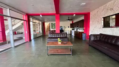 a living room with leather couches and a coffee table at Quinta Sunset, Lago de Coatepeque in El Congo