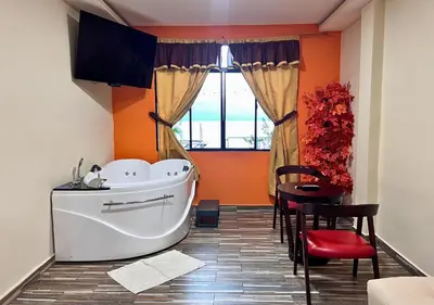 a bathroom with a white tub and a table and a window at Villa Noelia in El Jurón