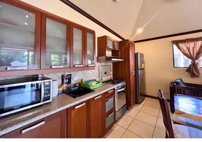 a kitchen with a microwave and a stove top oven at Villa Noelia in El Jurón