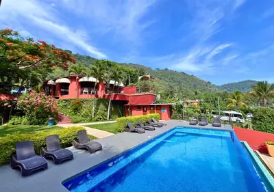 a swimming pool with chairs and a house at Villa Noelia in El Jurón