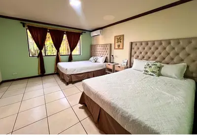 a bedroom with two beds in a room with green walls at Villa Noelia in El Jurón