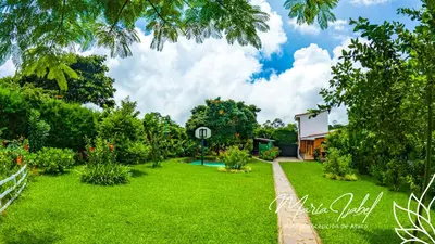 a green yard with a house in the background at Hotel María Isabel Ataco in Concepción de Ataco