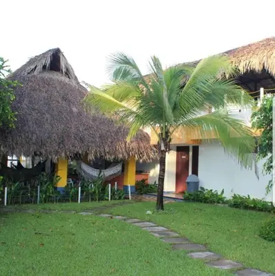 a building with a palm tree in front of it at Casa de Playa Bosque de Mangle en Playa El Espino in El Arco