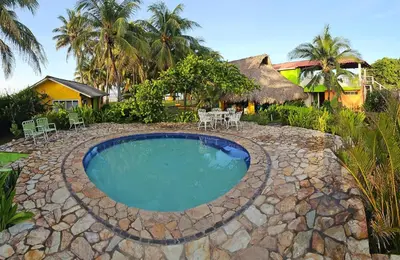 a swimming pool with chairs and a house at Casa de Playa Bosque de Mangle en Playa El Espino in El Arco