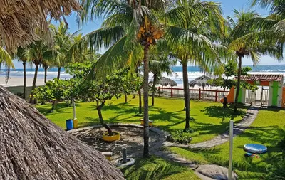 a view of the beach from a resort with palm trees at Casa de Playa Bosque de Mangle en Playa El Espino in El Arco