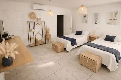 a hotel room with two beds and two tables at Habitación Agua - Villa Valle Campo in Nahuizalco