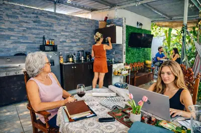 two women sitting at a table with a laptop at Habitación Agua - Villa Valle Campo in Nahuizalco