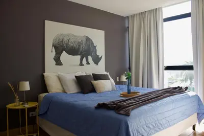 a bedroom with a blue bed with a picture of an elephant at Avitat Joy City &Volcano View 2Brm Pool &Gym in San Salvador