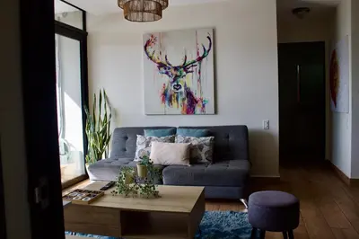 a living room with a blue couch and a table at Avitat Joy City &Volcano View 2Brm Pool &Gym in San Salvador
