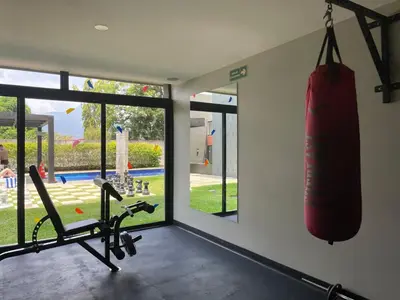 a gym with a punching bag hanging on the wall at Avitat Joy City &Volcano View 2Brm Pool &Gym in San Salvador