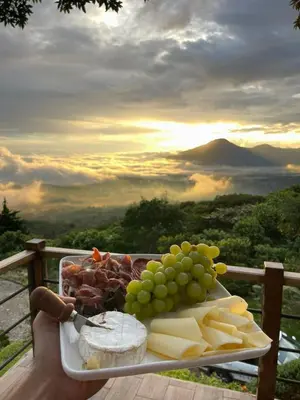 a tray of food with cheese and grapes on a table at PROVENZA en Los Naranjos in Juayúa