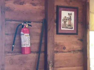 a fire extinguisher hanging on the wall of a cabin at PROVENZA en Los Naranjos in Juayúa