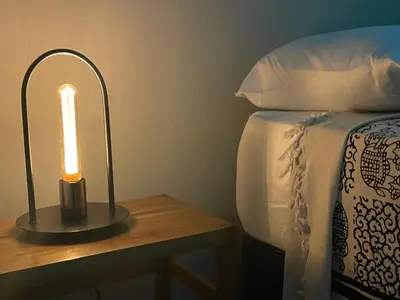 a lamp on a table next to a bed at LOOKING2GOOD in El Zonte