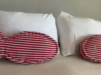 two pillows sitting next to each other on a bed at LOOKING2GOOD in El Zonte