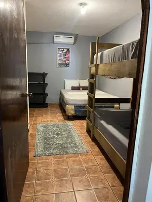 a room with two bunk beds and a door at Casa Makoi in Tamanique